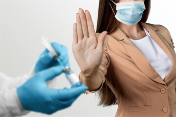 A woman wearing surgical mask refuse nurse injection or vaccination.