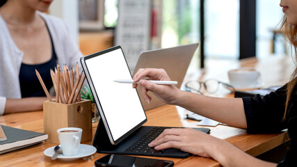 Close-up of a businesswoman hand holding a pen working using a tablet keyboard at the office. Mockup.