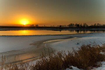 Wschód słońca zimową porą nad rzeką
