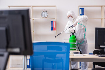 Old male contractor in office disinfection concept