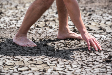 bare feet of a person on dry soil without plants close up