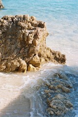 waves on the beach. Rocks on the beach with the sun casting light on it