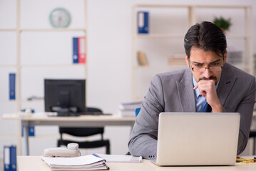 Naklejka premium Young male employee working in the office