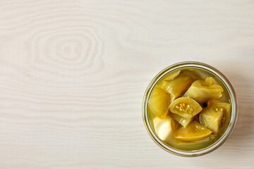 Pickled unripe green tomatoes. Canned homemade home-grown food in jars.