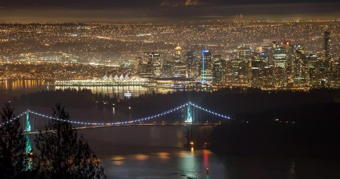 Aerial Lockdown Time Lapse Shot Of Illuminated Lions Gate Bridge Over Sea In City - Vancouver, Canada