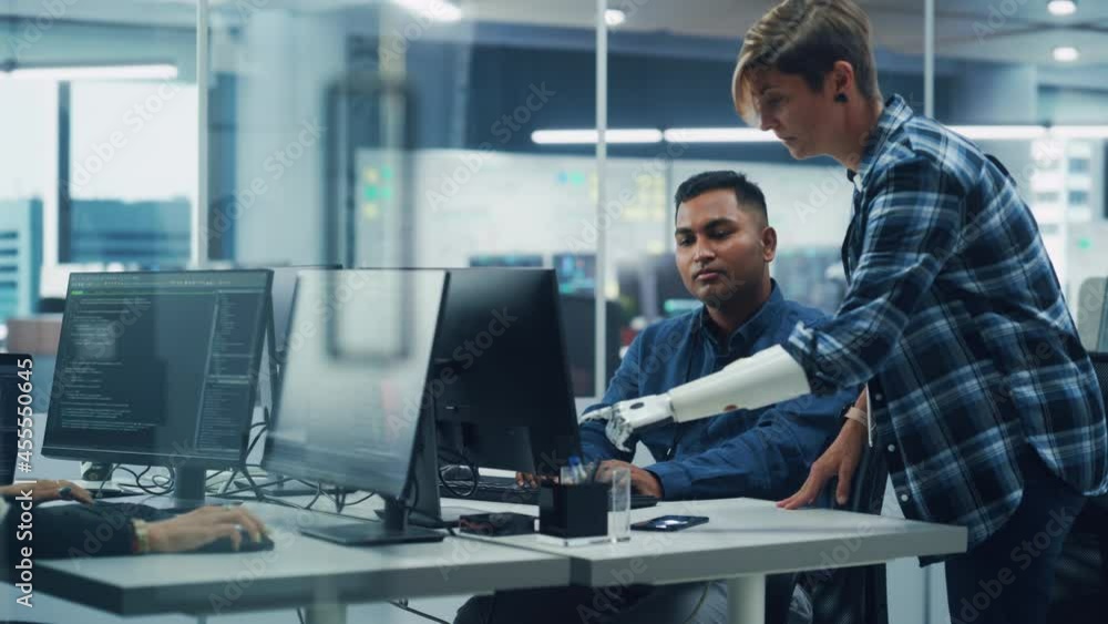 Poster Teamwork In Diverse Inclusive Office: Project Manager with Disability points Prosthetic Arm at Screen Talks with Indian Specialist Working on Computer. Professional Creative Software Engineers