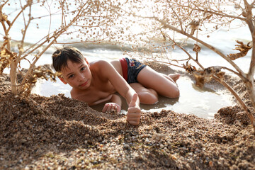 Kid resting on beach of Azov sea