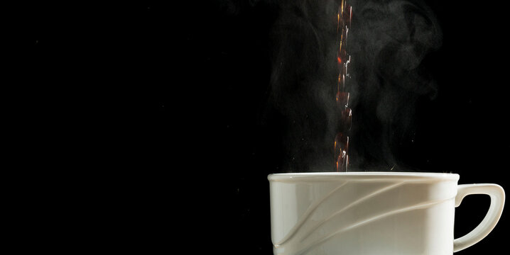 Caf&eacute; quente sendo derramado dentro de uma xicara de lou&ccedil;a branca. 