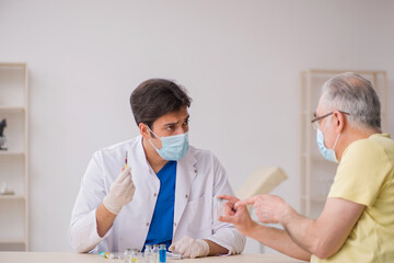 Obraz na płótnie Canvas Old male patient visting young male doctor in vaccination concep