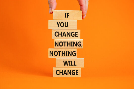 Change symbol. Wooden blocks with words 'If you change nothing, nothing will change'. Businessman hand. Beautiful orange background, copy space. Business, motivation and changes concept.