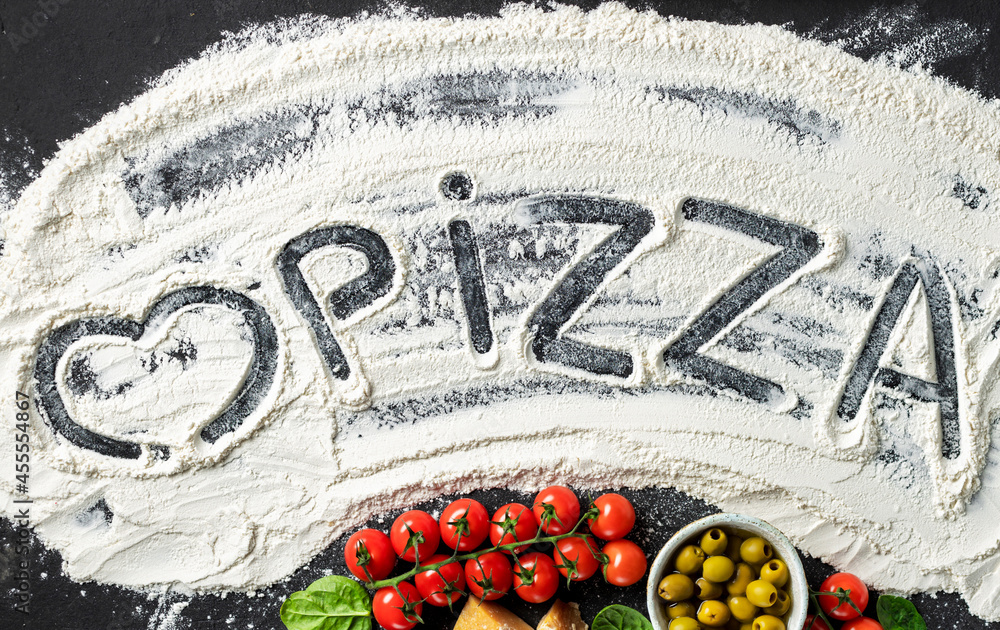 Poster word pizza and heart is written on flour with ingredients for making italian pizza, top view. abstra