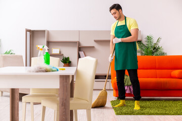 Young male contractor cleaning the house indoors