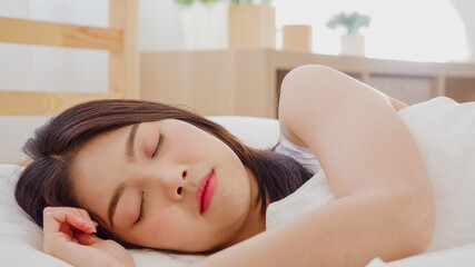 Obraz na płótnie Canvas Asian woman dreaming while sleeping on bed in bedroom, Beautiful japanese female using relax time lying on bed at home. Lifestyle women using relax time at home concept.