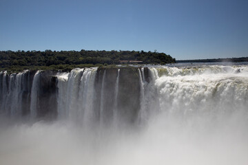 Natural world wonder. View of the Iguazu falls seen from Garganta del Diablo, in the frontier between Argentina and Brazil. The waterfalls falling white water texture and mist in the tropical forest.