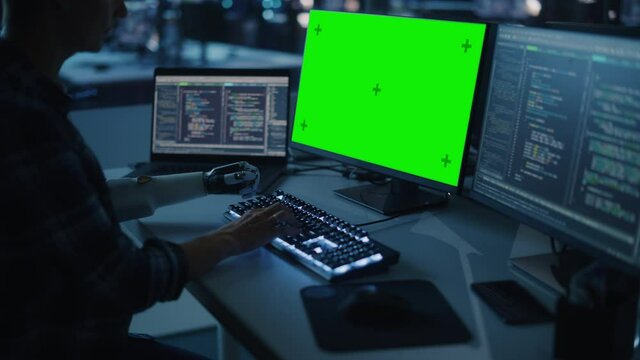 Night Office: Person with Disability Using Prosthetic Arm to Work on Green Screen Chroma Key Computer. Swift and Natural Use of Myoelectric Bionic Hand To Type Code for Software at Night. Medium Arc