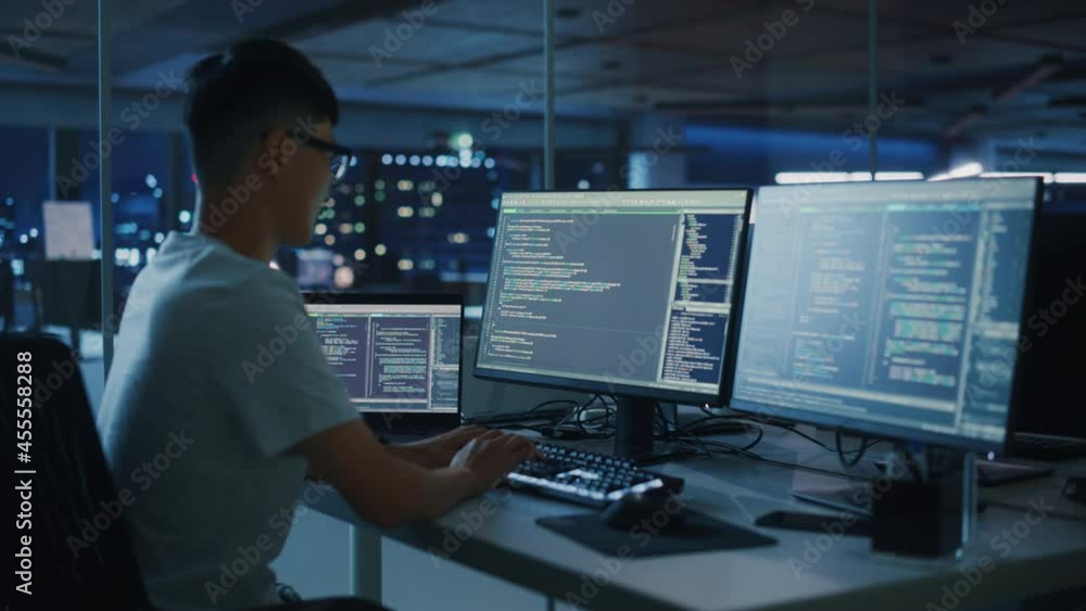 Leinwandbilder Night Office: Young Japanese Man in Working on Desktop Computer. Digital Entrepreneur Typing Code, Creating Modern Software, e-Commerce App Design, e-Business Programming. Over Shoulder