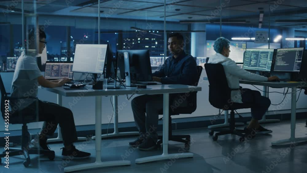 Aufkleber Diverse Office at Night: Multi-Ethnic Team of Young Programmers Working on Desktop Computers, Screens Show Coding Language User Interface. Software Engineers Create Innovative e-Commerce App. Wide