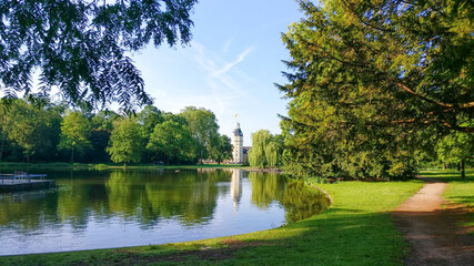 View of Karlsruhe Palace tower from the lake in the Palace gardens or schlossgarten in Germany. A landscape park for recreational and event activities, picnics and outdoor sports.