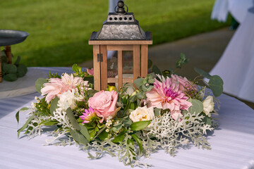 Lantern with flowers around it at wedding