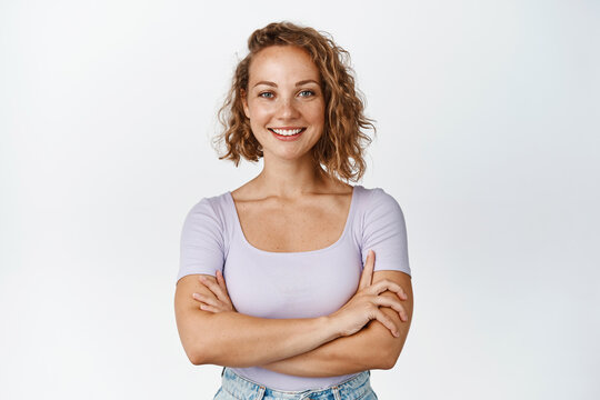Stylish young woman cross arms on chest, smiling and looking confident at camera