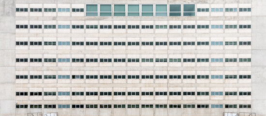 Front view of symmetrical concrete building facade with window grid