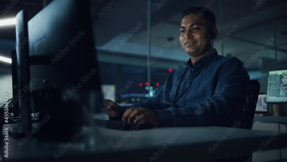 Poster Night Office: Portrait of Handsome Indian Man in Working on Desktop Computer. Digital Entrepreneur Typing, Creating Modern Software, e-Commerce App Design, Programming. Successful Smiling Man
