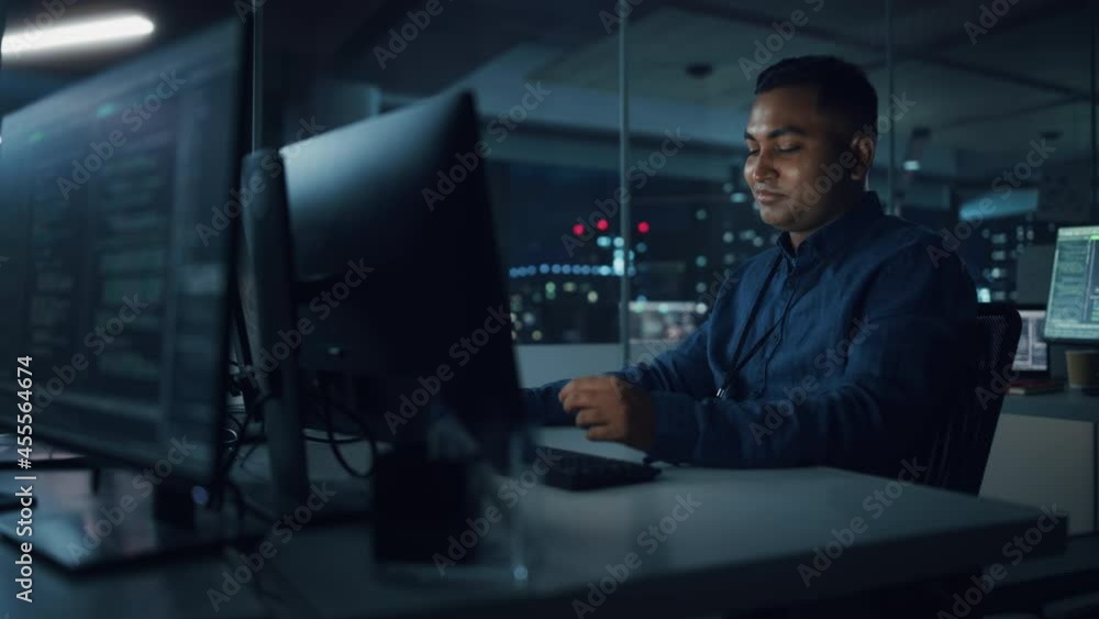 Poster Night Office: Portrait of Handsome Indian Man in Working on Desktop Computer. Digital Entrepreneur Typing, Creating Software, e-Commerce App Design, Programming. Thoughtful Happy Man Finding Solution