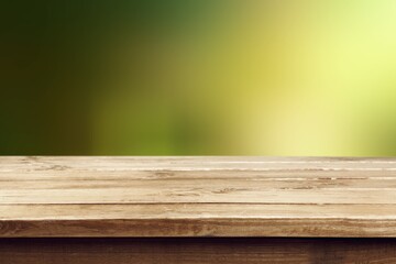 Wooden table or bench on green blurred outdoor background.