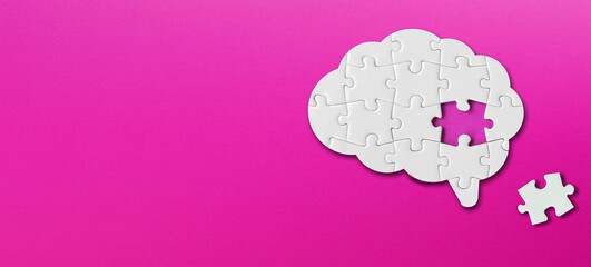 Brain shaped white jigsaw puzzle with copy space on purple background, a missing piece of the brain puzzle, mental health and problems with memory