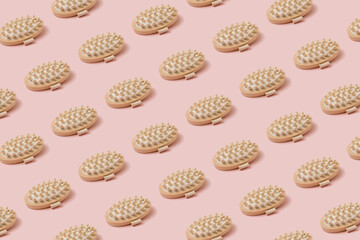 Massage wooden brushes on vibrant pastel pink background. Eco friendly self care and wellness concept.