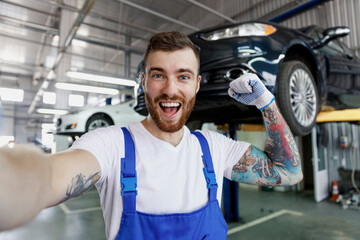 Close up happy young professional technician mechanic man in blue overalls t-shirt do selfie shot...