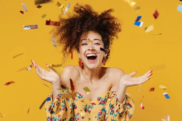 Foto op Plexiglas Young happy satisfied excited fun surprised amazed woman 20s with culry hair in casual clothes tossing throwing confetti isolated on plain yellow background studio portrait. People lifestyle concept. © ViDi Studio