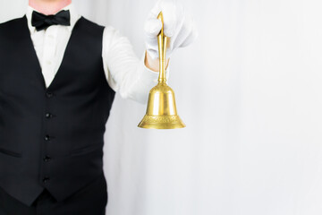 Portrait of Butler or Waiter in White Gloves Holding Gold Bell on White Background. Copy Space for Service Industry and Professional Hospitality. 