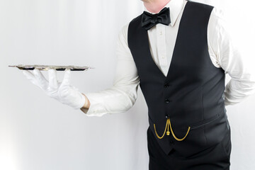 Portrait of Butler or Waiter in White Gloves Holding Silver Serving Tray. Concept of Service...