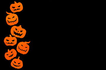 Halloween holiday concept, paper orange pumpkins on a black background. High quality photo