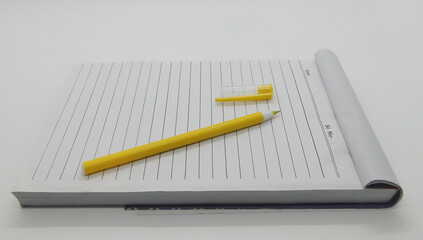 Open Writing Pad and Yellow Pen on White Background