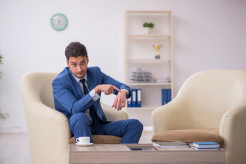 Young male employee waiting for business meeting
