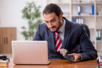 Young male employee holding wallet in remuneration concept