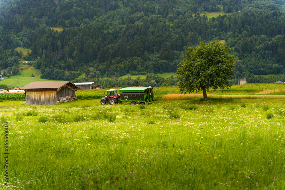 Poster Tractor parked near the small wooden barn on a farm