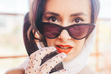 beautiful young woman happily speaks on the phone in an english style red telephone booth. girl...