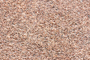 The mottled surface of the granite slab is finely speckled. Uniform texture of natural stone.