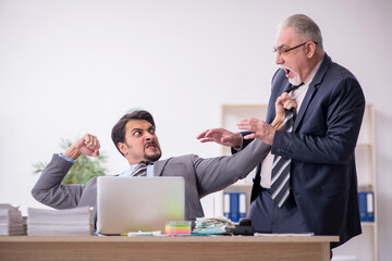 Two male employees in bullying concept