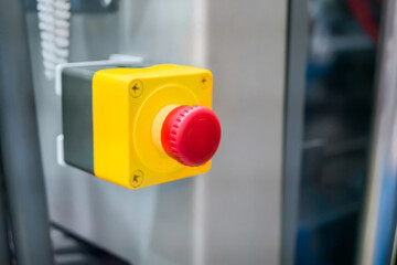 Close up view: machine control panel with power red switch button - emergency stop at factory, plant. Industrial, electronic, technology equipment concept