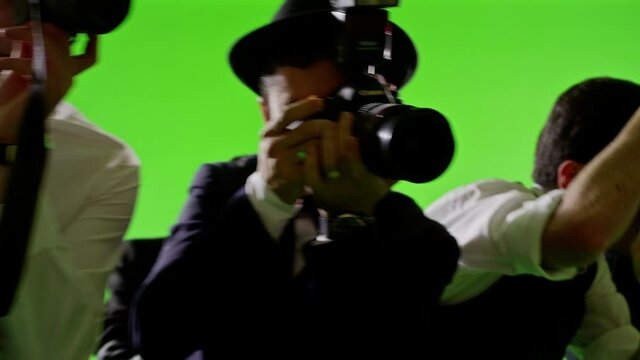 Group of paparazzi or journalists on green screen . Group of photographers photo shooting on green screen. Slow motion. Shot on RED EPIC Cinema Camera.