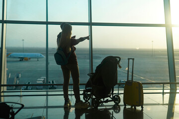 mother and son looking at the plane to the airport. Waiting flight.