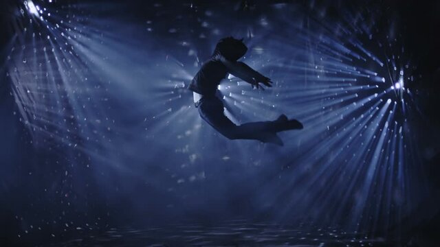 Professional contemporary ballet dancer dancing and jumping on beautiful background wiyh light lines. Slow Motion. Shot on RED EPIC Cinema Camera.