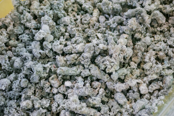 Plastic recycling, renewable resource - heap of secondary soft plastic granules - polystyrene, polyethylene, polypropylene pellets at exhibition, trade show - close up top view