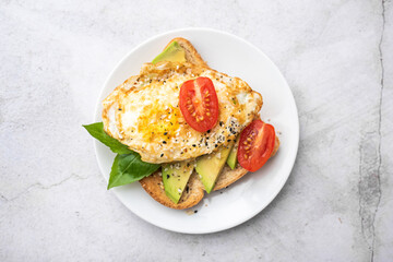 Avocado toast breakfast with fried egg, top view.