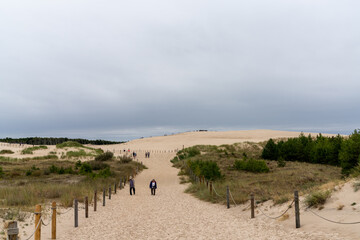 tourists enjoy a visit to the sand dunes of Slowinksi National Park in northern Poland