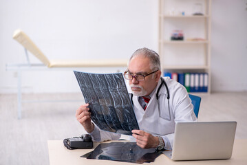 Old male doctor radiologist working in the clinic